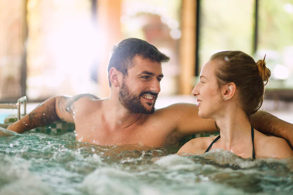 Men and women relaxing in bathtub