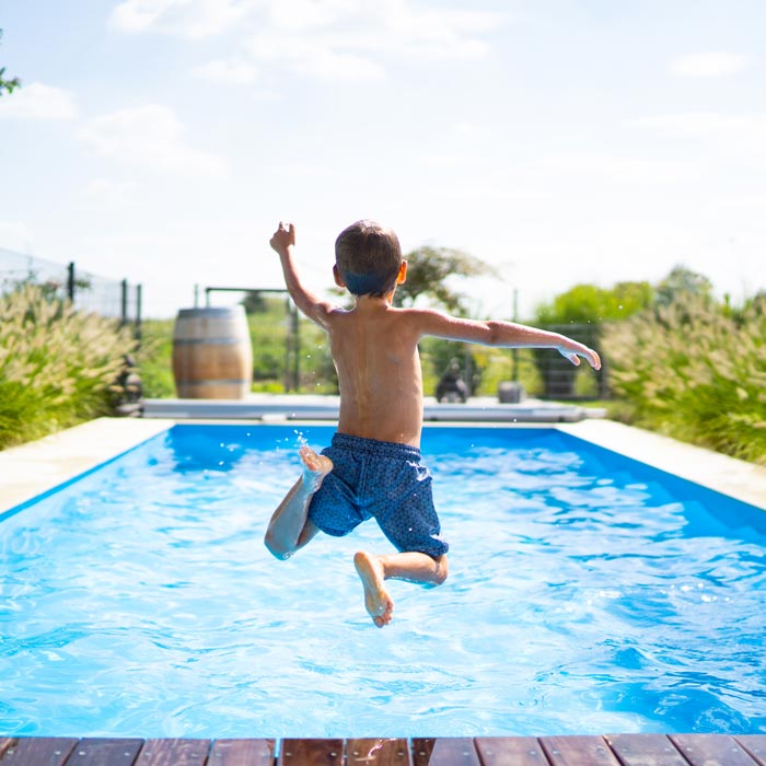 boy jumping into pool