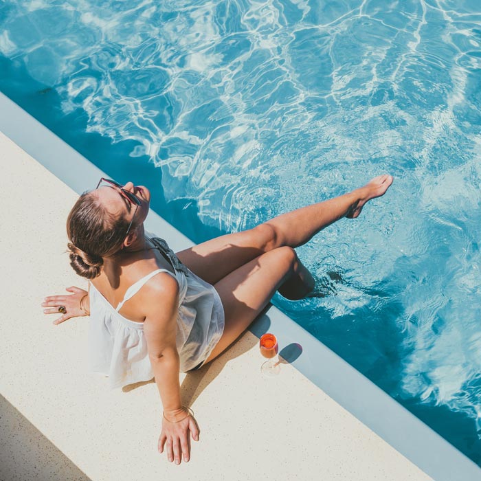 woman sitting on edge of pool