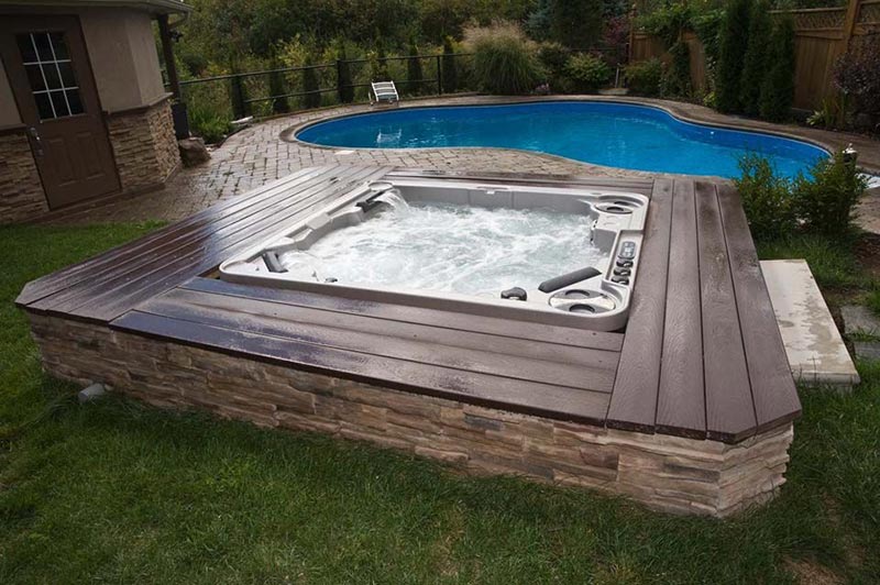 in ground pool with raised hot tub