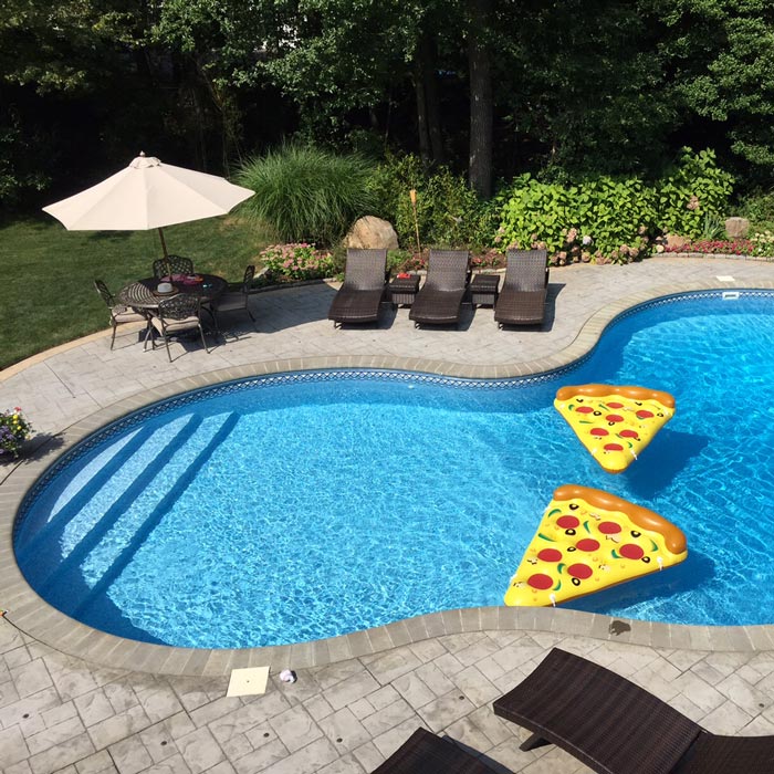 in-ground pool with pizza slice floaties