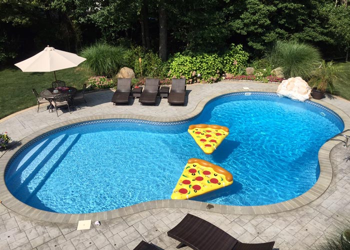 in-ground pool with pizza slice floaties